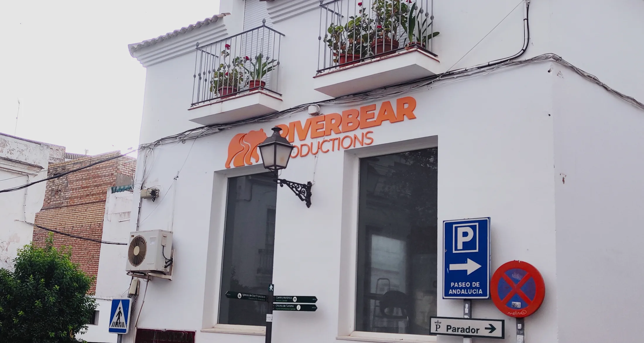 Fachada del local de Riverbear Productions en Arcos de la Frontera con el rótulo naranja